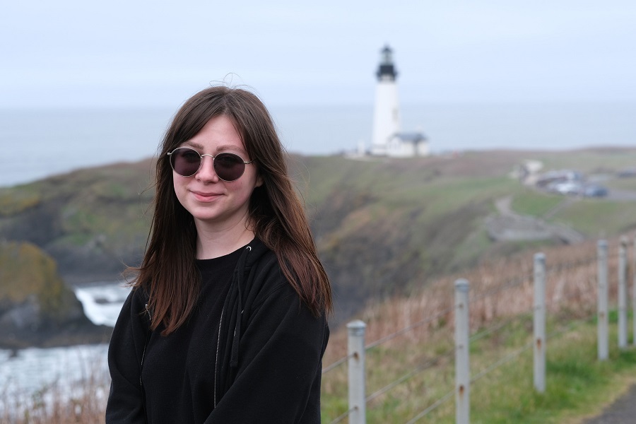 Woman smiling infront of a lighthouse